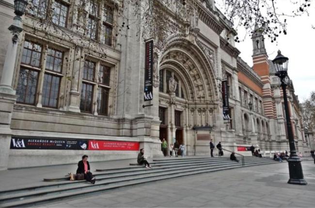 People sit on steps outside a museum.