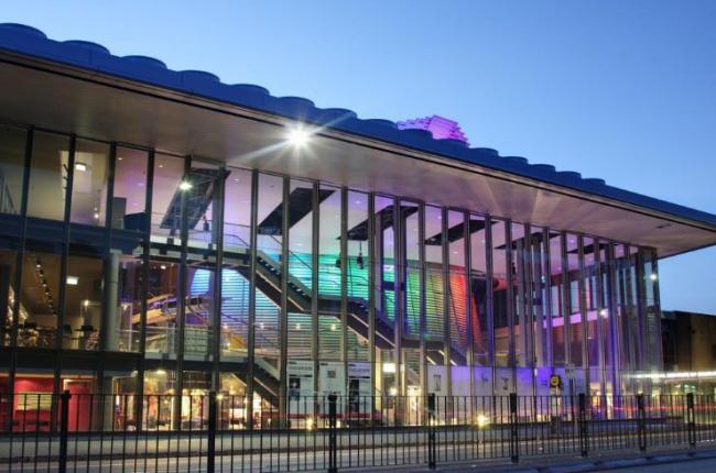 A performing arts center lobby with floor to ceiling windows. 